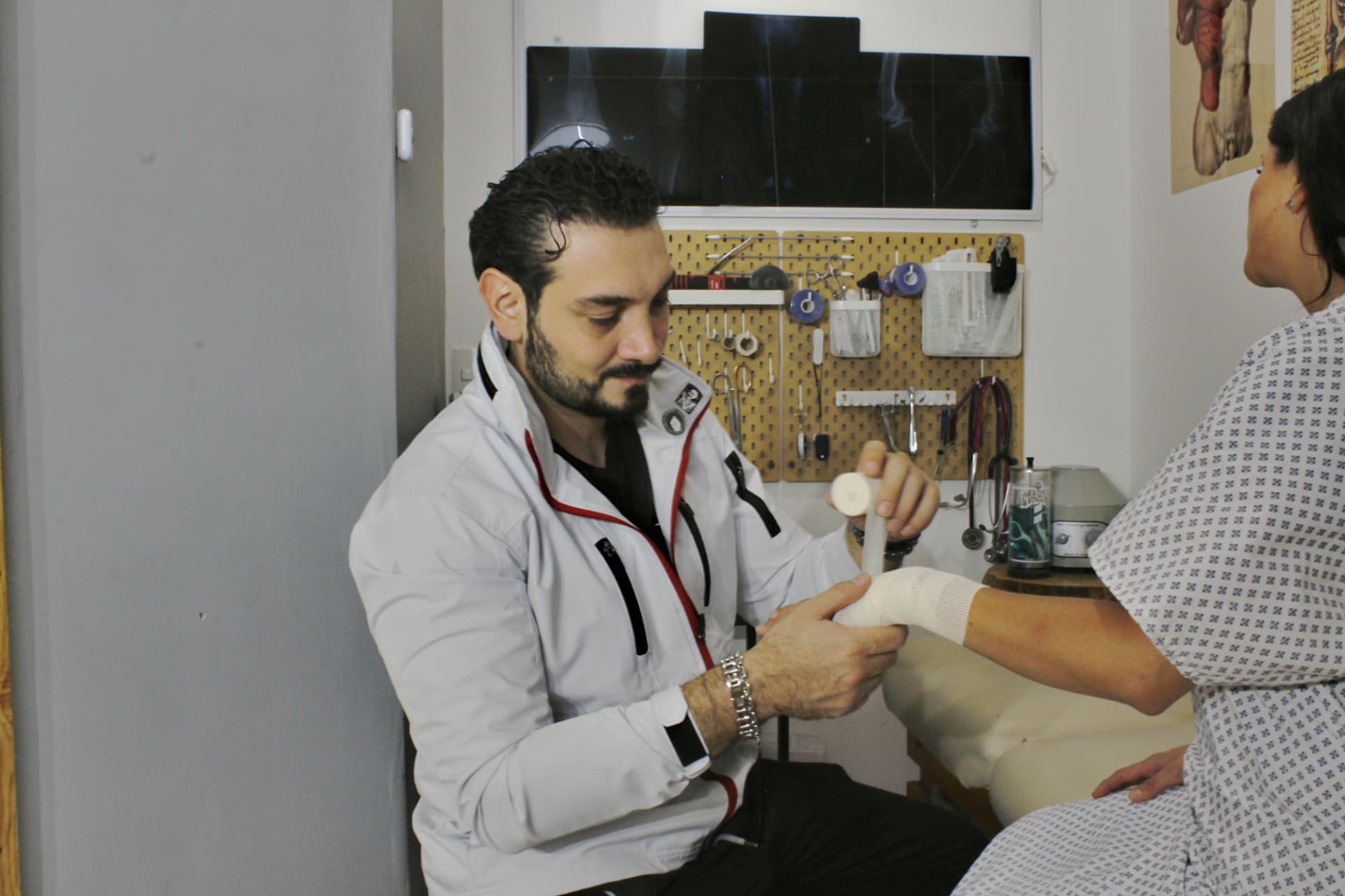 Dr. Luis Olivares atendiendo a una paciente en consulta